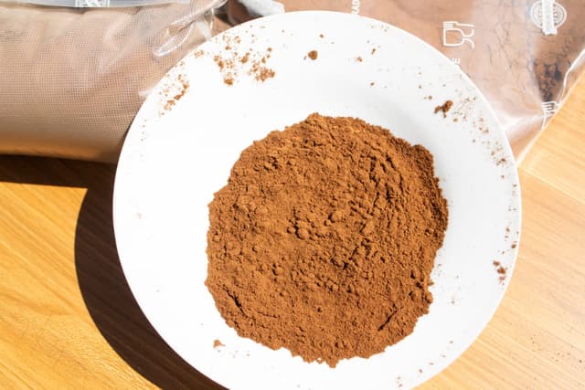 Pure Madagascar vanilla bean powder on a plate, fine dark ground vanilla